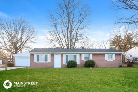 a small brick house with a lawn in front of it