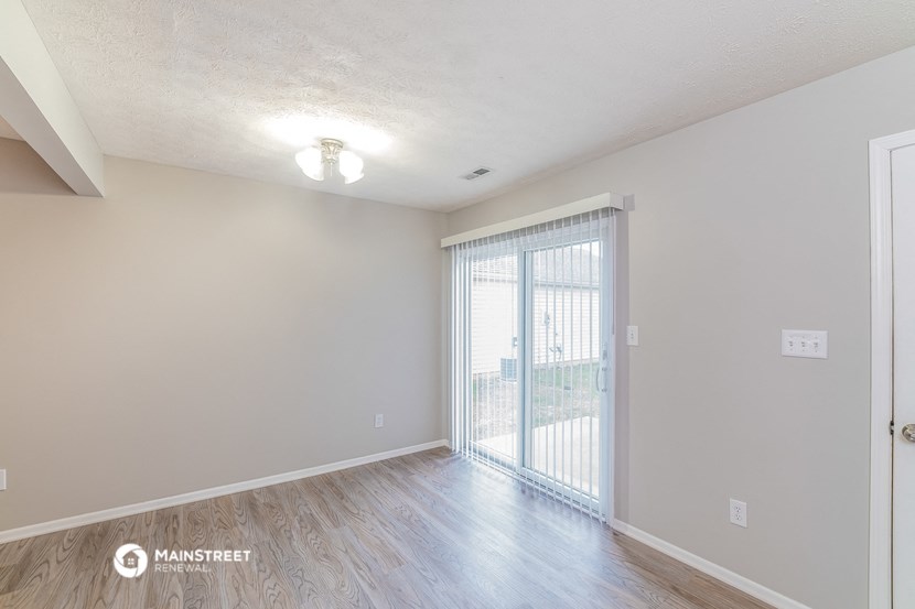 a spacious living room with sliding glass doors to a balcony