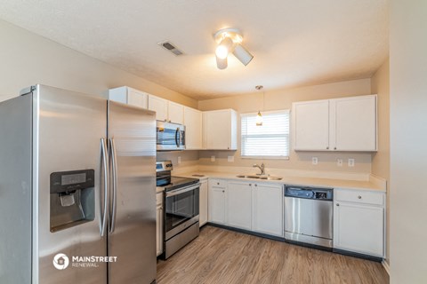 a kitchen with stainless steel appliances and white cabinets