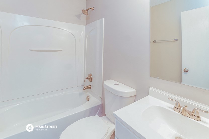 a white bathroom with a tub and a toilet and a sink