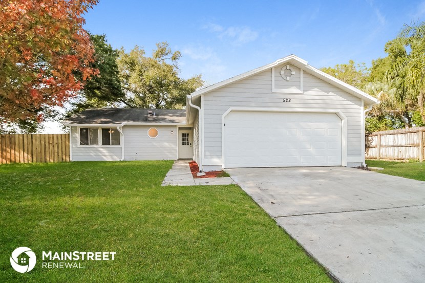 a white house with a driveway and a lawn