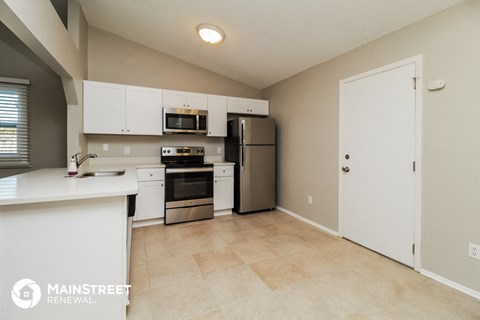 a large kitchen with stainless steel appliances and white cabinets