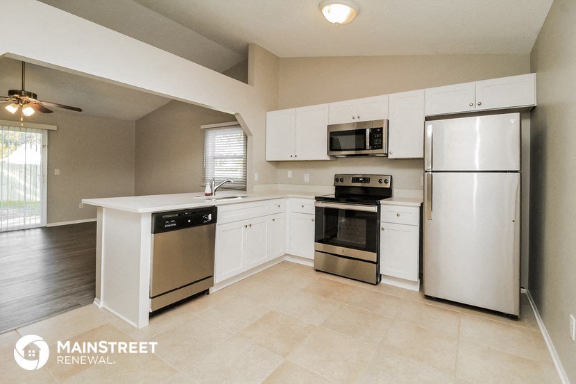 a kitchen with white cabinets and stainless steel appliances