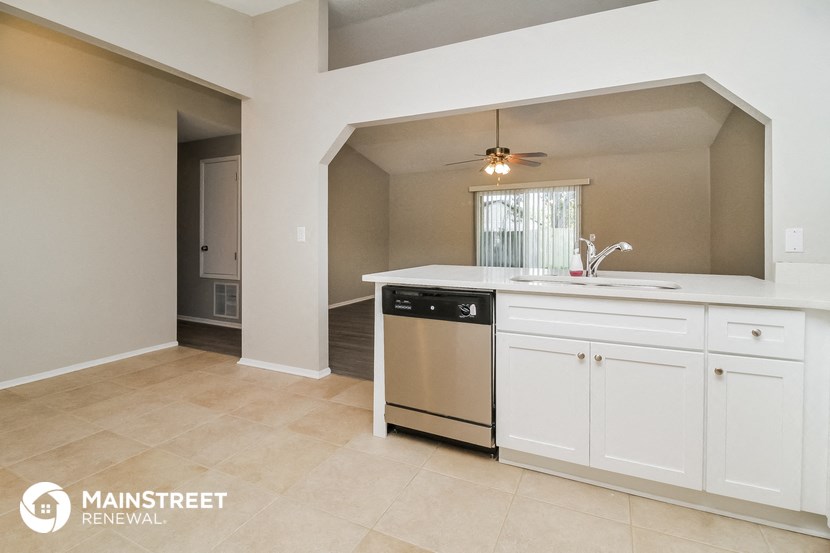 a kitchen with white cabinets and a sink and a dishwasher