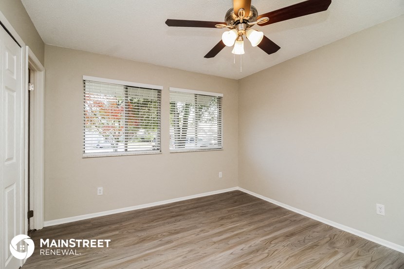 a living room with a ceiling fan and a window