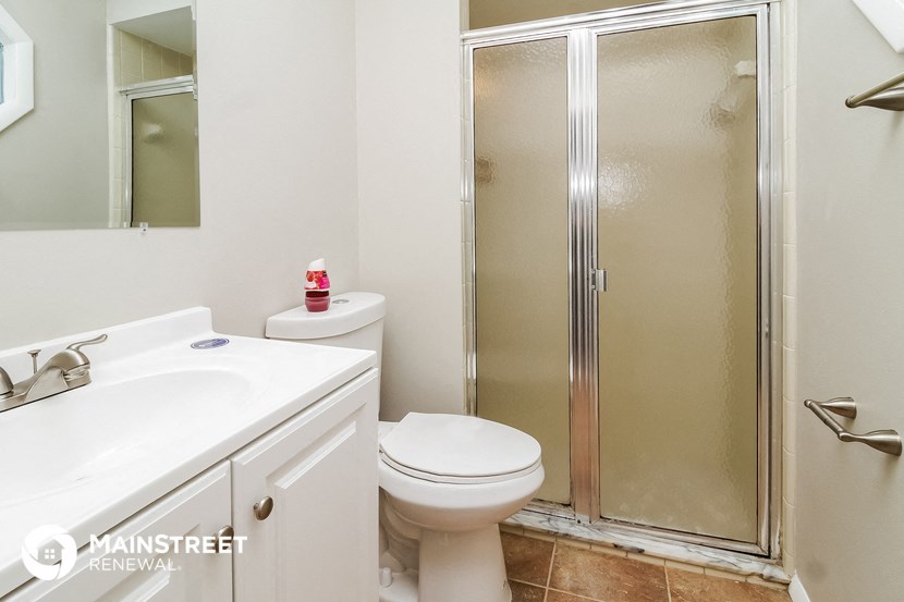 a bathroom with a shower and a toilet and a sink