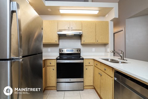 a kitchen with wooden cabinets and stainless steel appliances