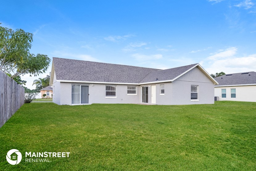 a white house with a yard and a fence