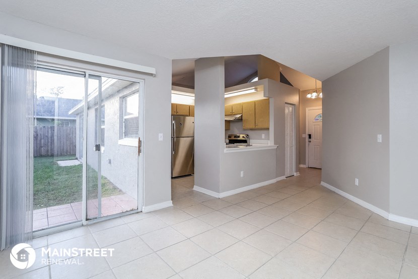 a spacious living room with a sliding glass door to the yard