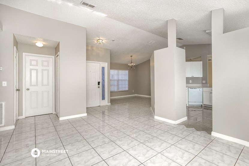 an empty kitchen and living room with a tile floor