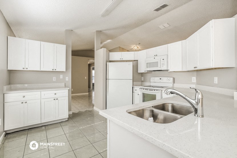 a kitchen with white cabinets and a sink