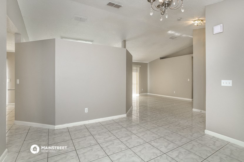 the living room and dining room of an empty house
