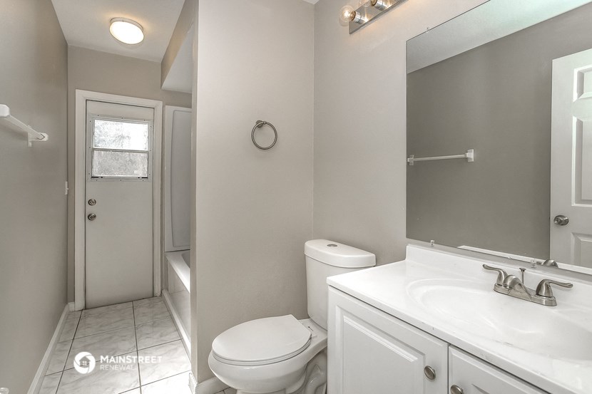 a white bathroom with a toilet and a sink