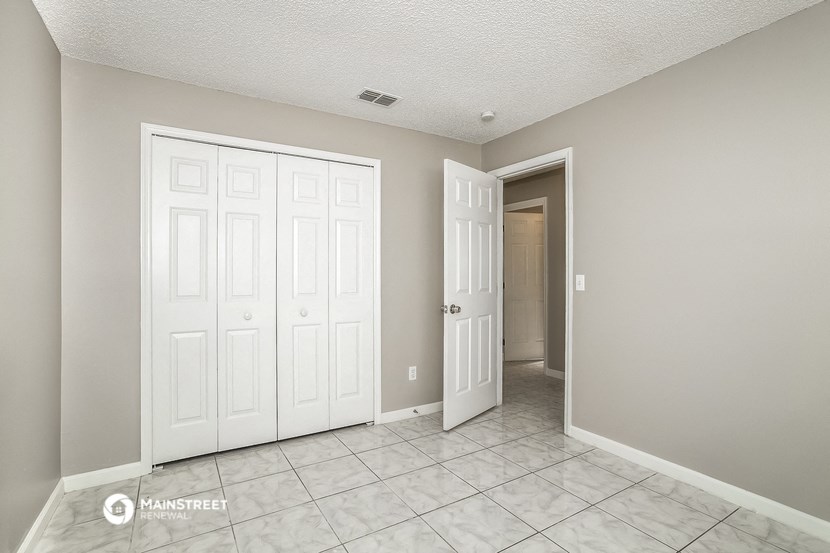 an empty room with two closets and a door to a hallway
