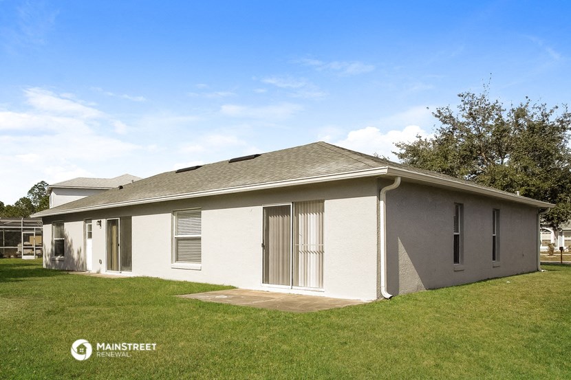 a small white house with a grassy yard and a garage