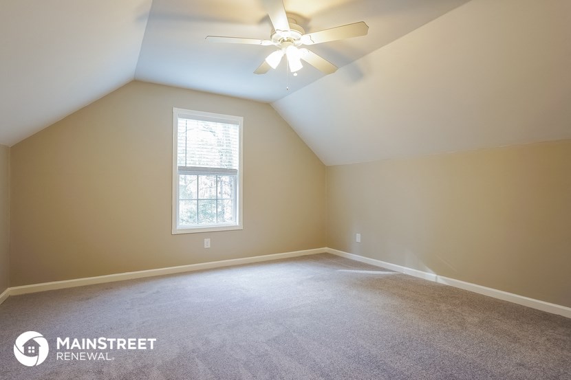 an empty room with a ceiling fan and a window