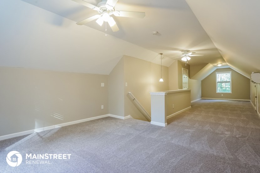 the living room and dining room of a home with a ceiling fan