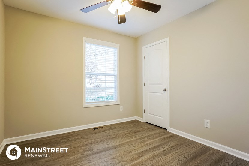 a bedroom with a ceiling fan and a white door
