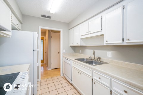 a kitchen with white cabinets and a sink and a refrigerator