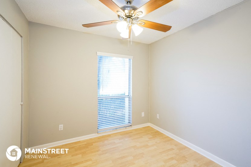 a living room with a ceiling fan and a window