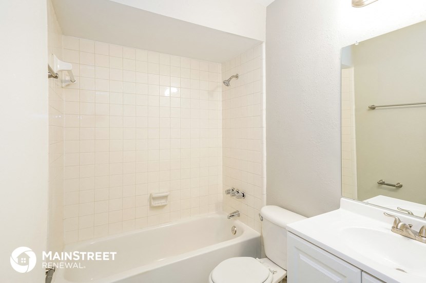 a white bathroom with a tub and a sink and a toilet