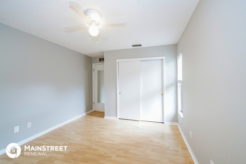 a living room with a wood floor and a ceiling fan