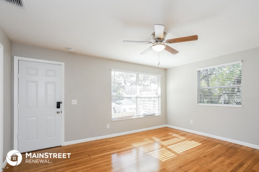 an empty room with a ceiling fan and a white door