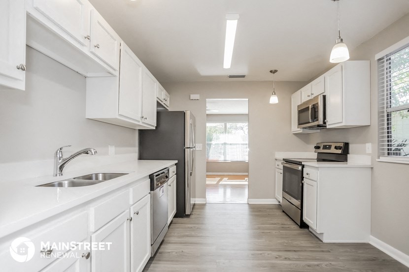 a kitchen with white cabinets and stainless steel appliances
