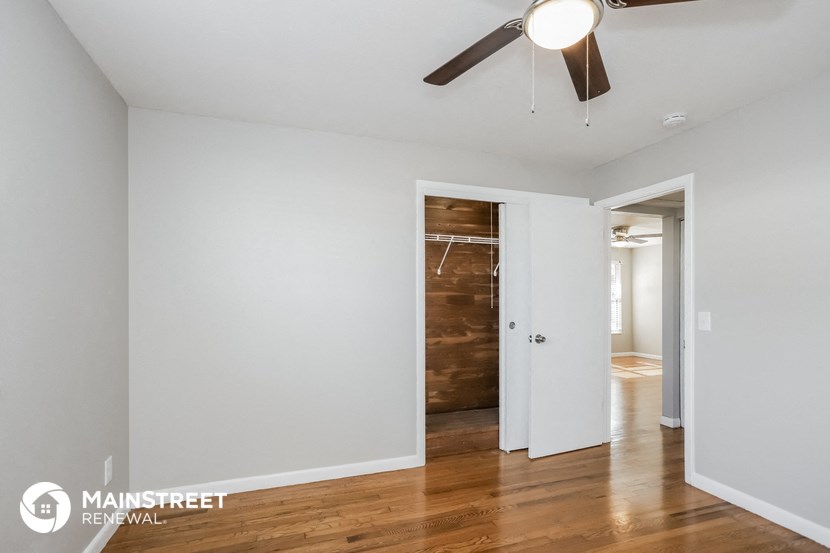 a bedroom with a closet and a ceiling fan