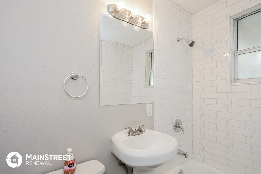 a white bathroom with a sink and a mirror