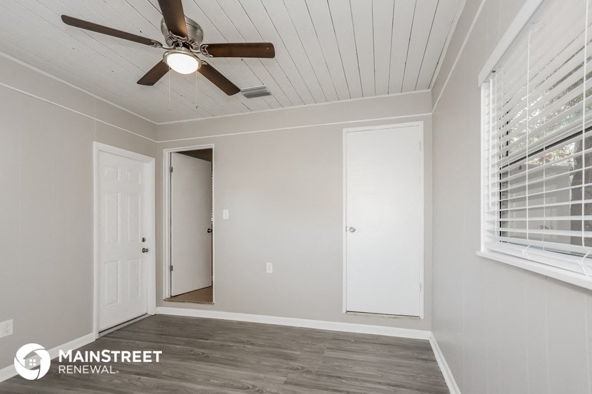 a bedroom with a ceiling fan and a door to a closet