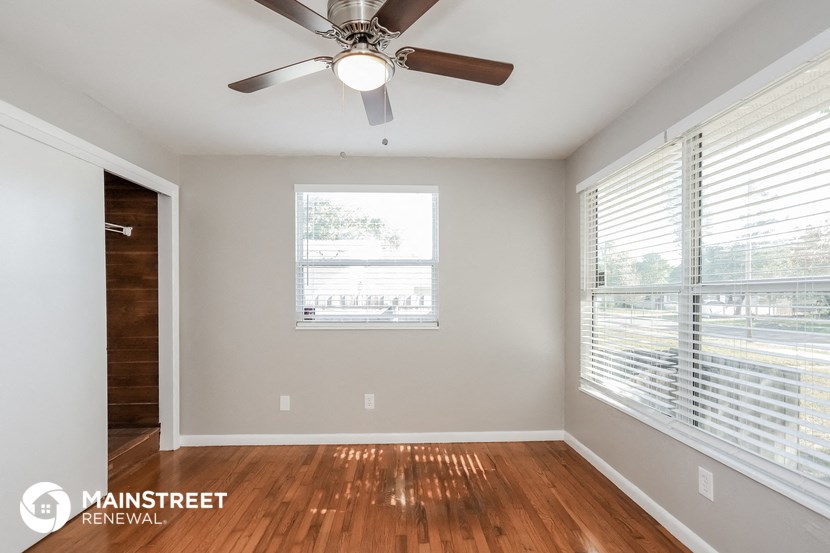a living room with a ceiling fan and a window