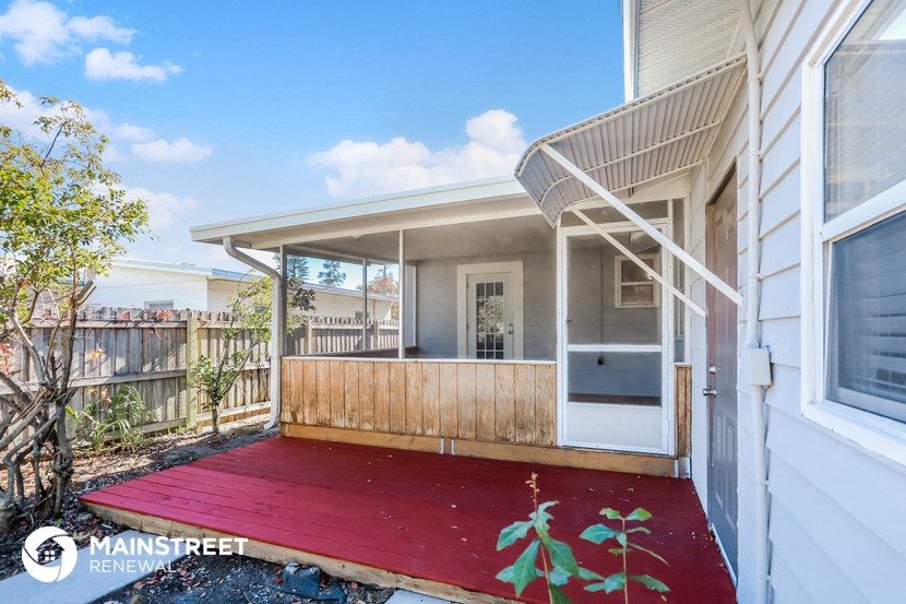 a small house with a red deck in front of it