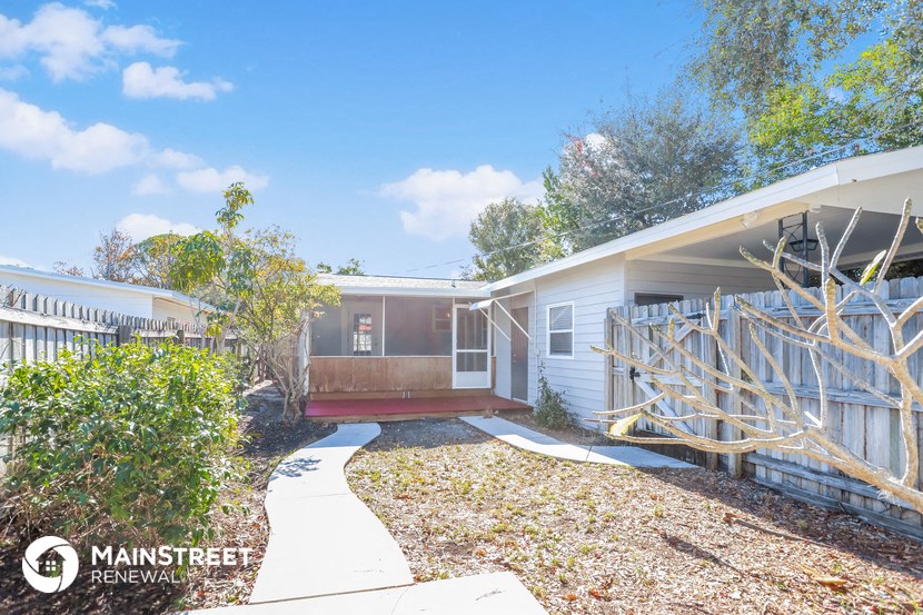 a small house with a yard and a wooden fence