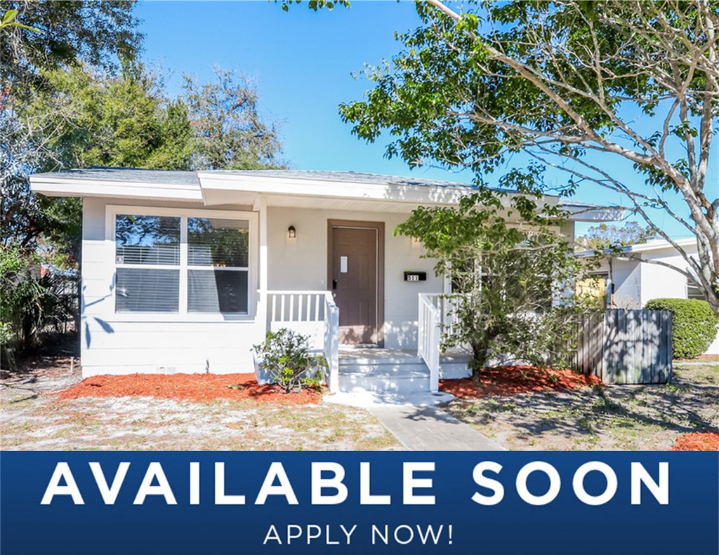 a small white house with a porch and trees