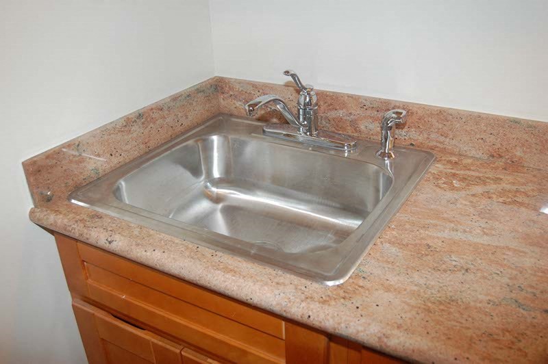 a stainless steel sink in a granite counter top