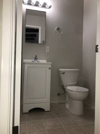 a bathroom with a toilet and a sink and a mirror