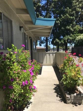 a porch with flowers in front of a building