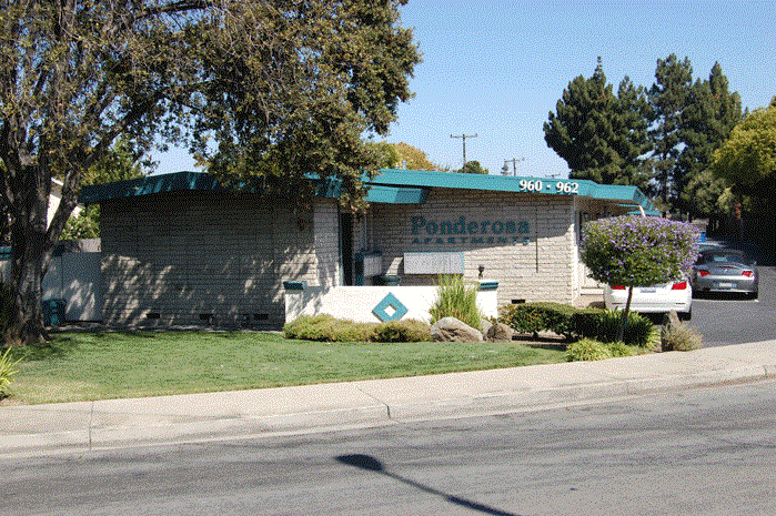 a brick building with a green roof on the side of a street