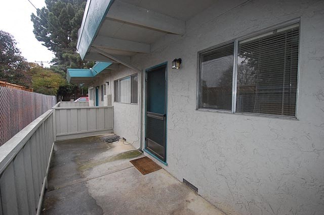 a white house with a porch and a blue door
