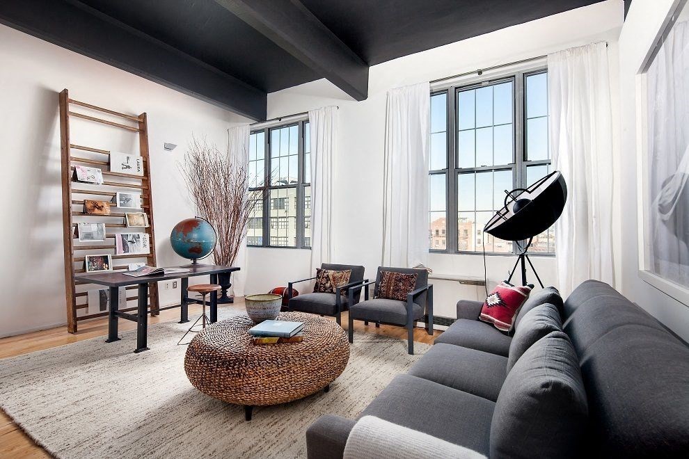 a living room with a black ceiling and a gray couch