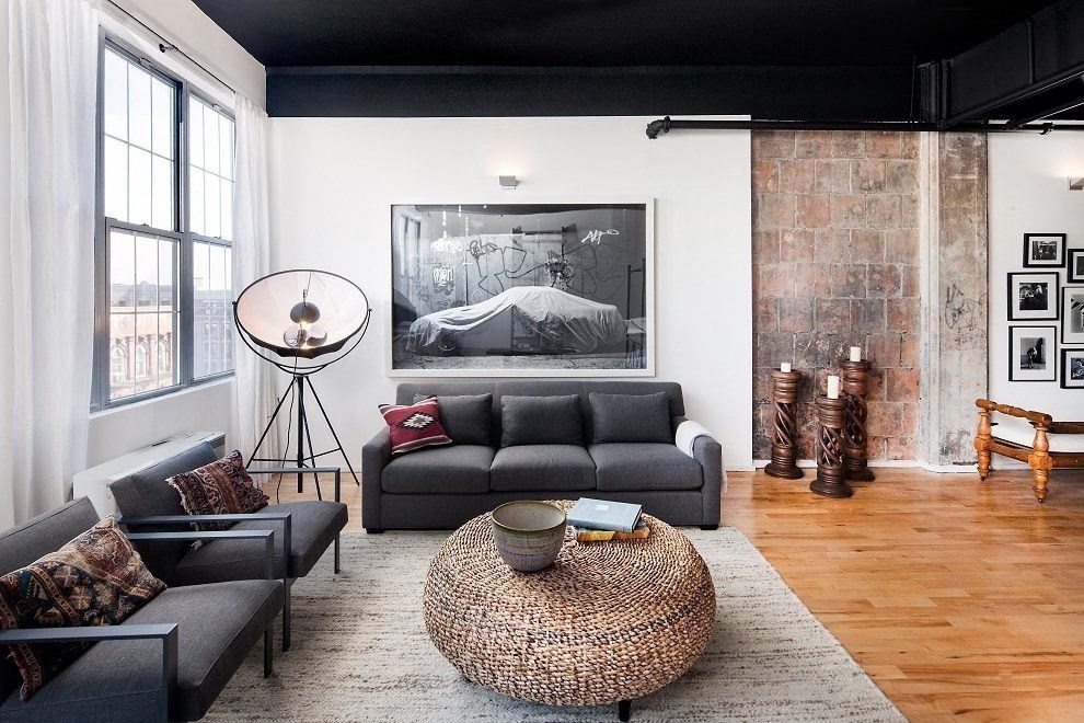 a living room with a gray couch and a rug     and a