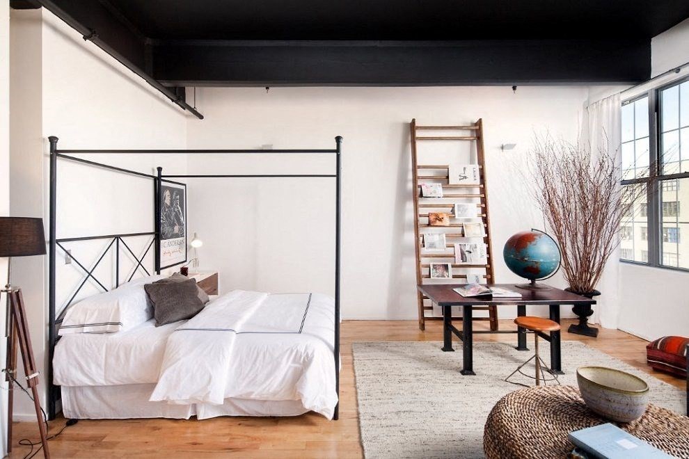 a bedroom with a bed and a ladder in a loft
