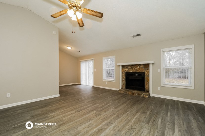 the living room with fireplace and wood flooring