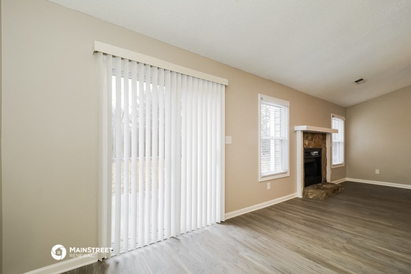 the spacious living room with sliding glass doors to the fireplace
