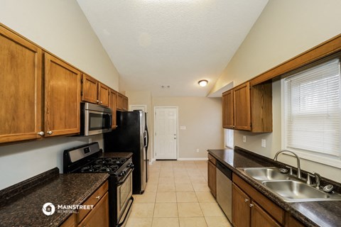 a kitchen with black appliances and wooden cabinets