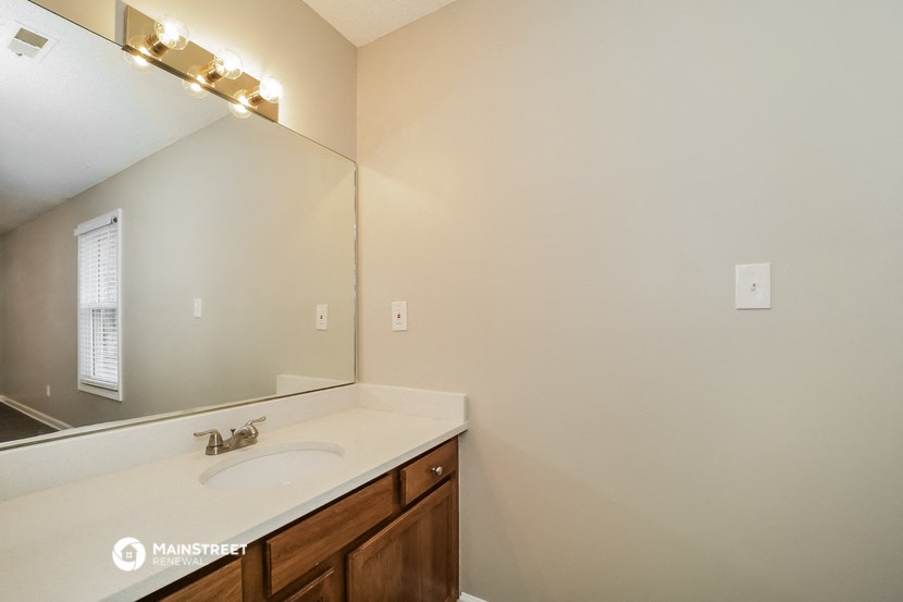 the master bathroom has a large mirror and a sink