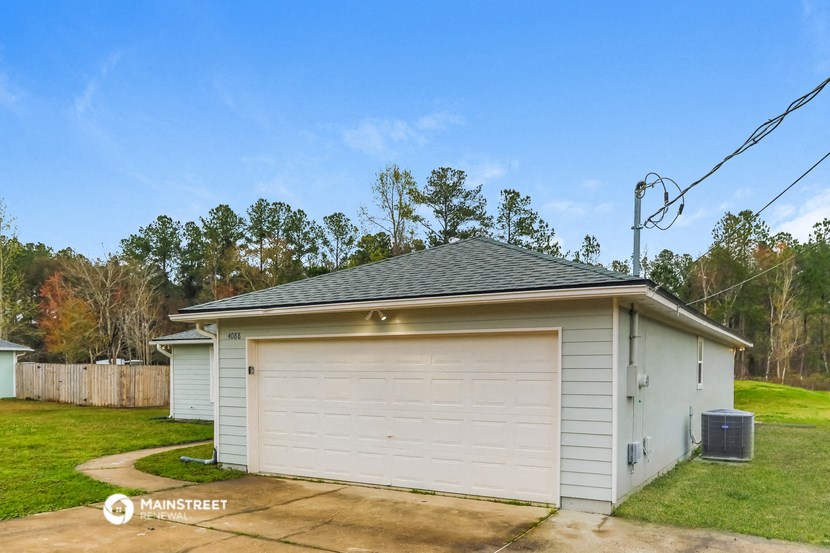 a small white garage with a gray roof on top of it
