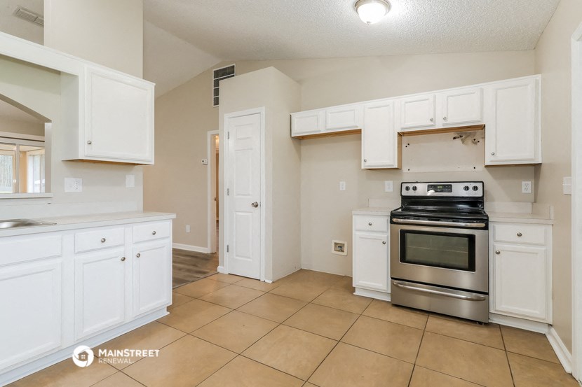 a kitchen with white cabinets and stainless steel appliances