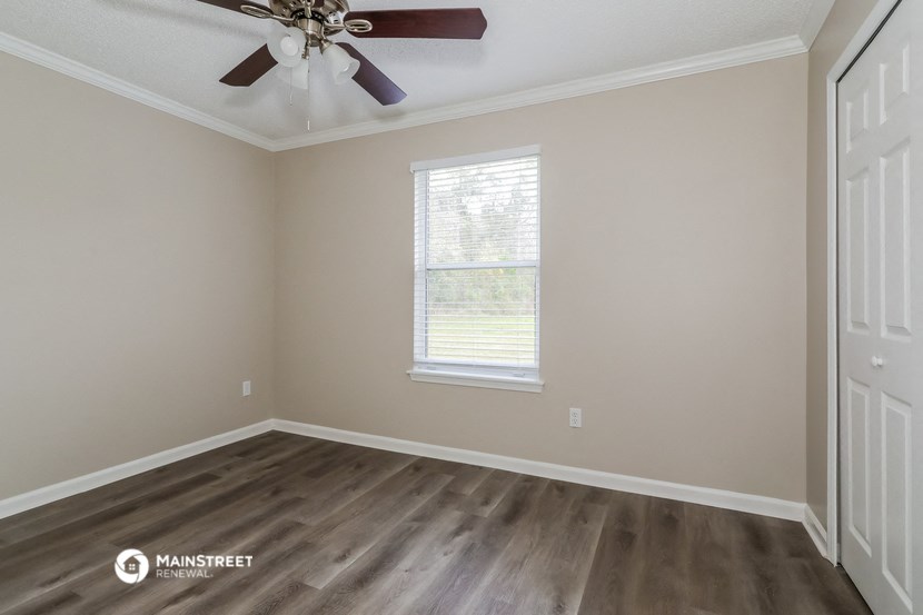 an empty room with a ceiling fan and a window